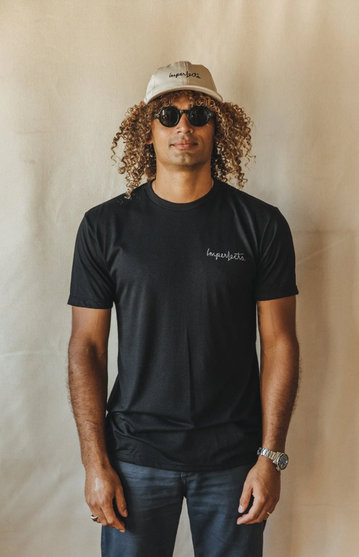 A man wearing a Imperfects Overalls tee w/ brushstroke in black