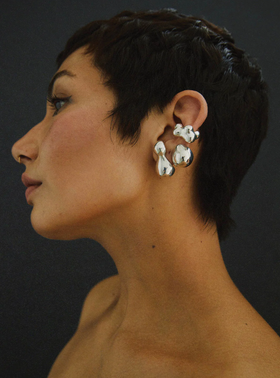 A woman wearing a Faris bolo stud earring