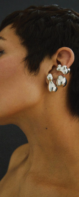 A woman wearing a Faris bolo stud earring