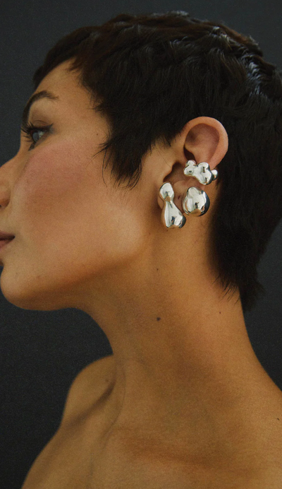 A woman wearing a Faris bolo stud earring