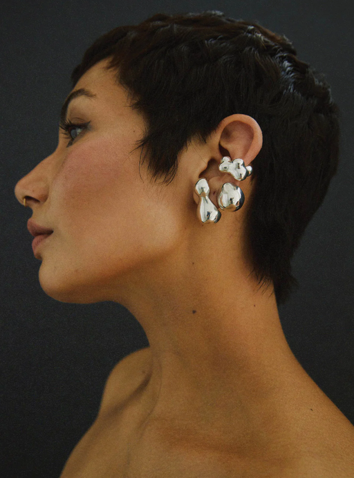 A woman wearing a Faris bolo stud earring