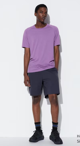 A man wearing a Kaws dry-ex short sleeve purple t-shirt