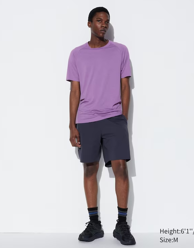 A man wearing a Kaws dry-ex short sleeve purple t-shirt