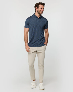 A man wearing a Into The Am navy color performance polo - non-branded