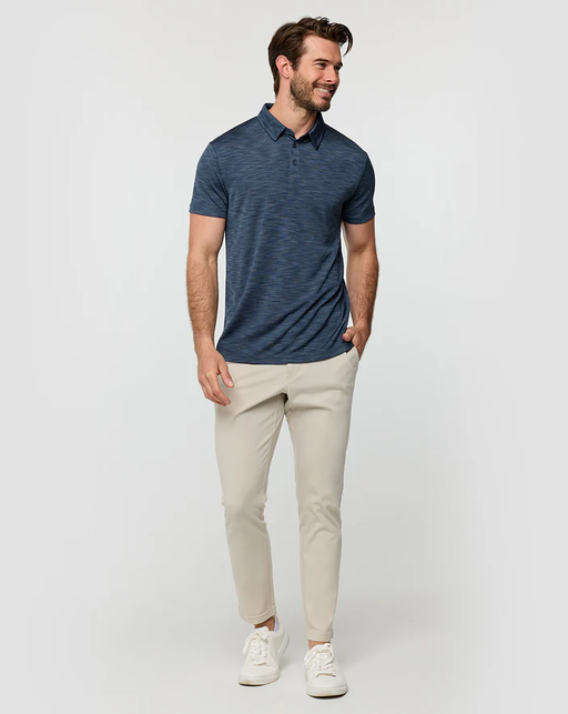 A man wearing a Into The Am navy color performance polo - non-branded