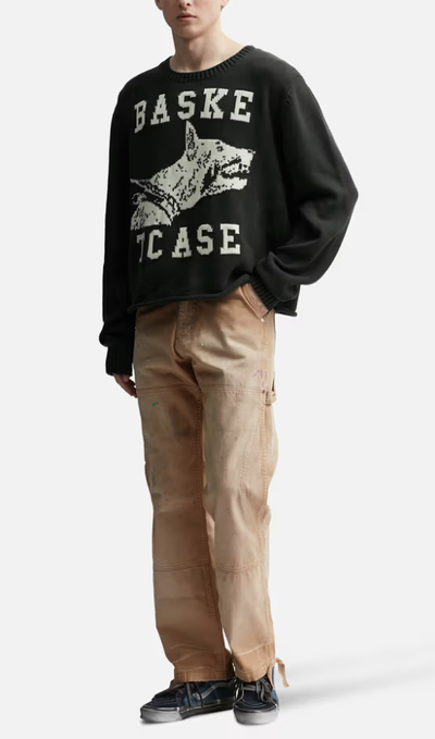 A man wearing a BasketCase raw college knit black sweater