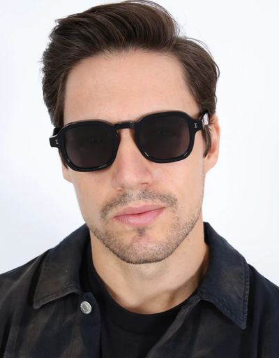 A man wearing a Illesteva black washington sunglasses