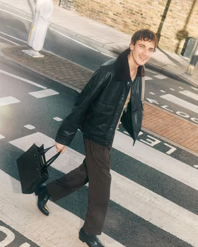 A man carrying a Jimmy Choo black bag