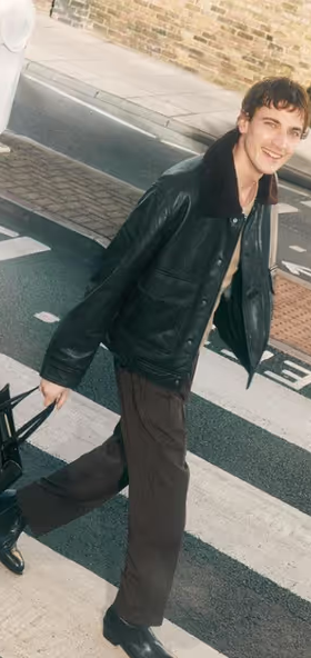 A man carrying a Jimmy Choo black bag