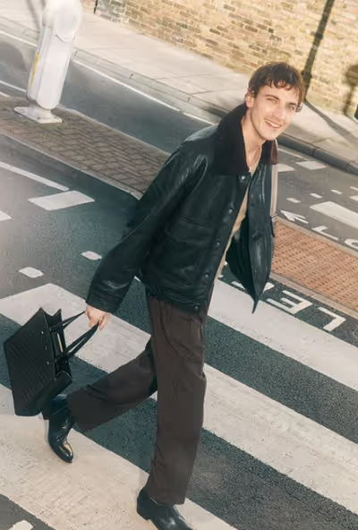 A man carrying a Jimmy Choo black bag