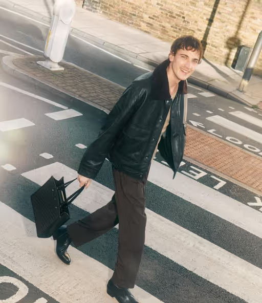 A man carrying a Jimmy Choo black bag