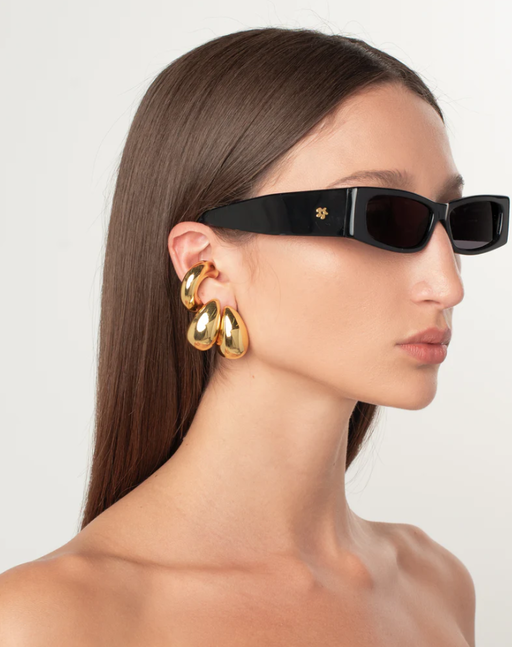 A woman wearing a ÉLIOU varsity ear cuff