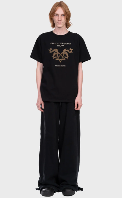 A man wearing a Midnight Studios greatest love songs t-shirt - black