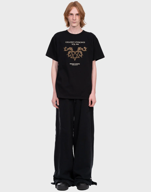 A man wearing a Midnight Studios greatest love songs t-shirt - black
