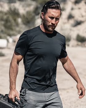 A man wearing a Ten Thousand black tactical shirt