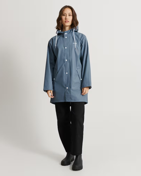 A woman wearing a Tretorn stone blue color wings rain jacket