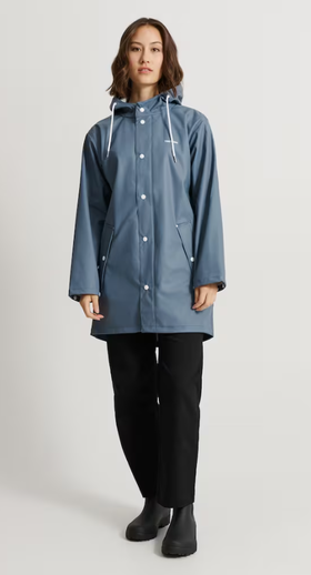 A woman wearing a Tretorn stone blue color wings rain jacket