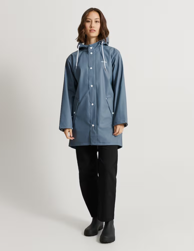 A woman wearing a Tretorn stone blue color wings rain jacket