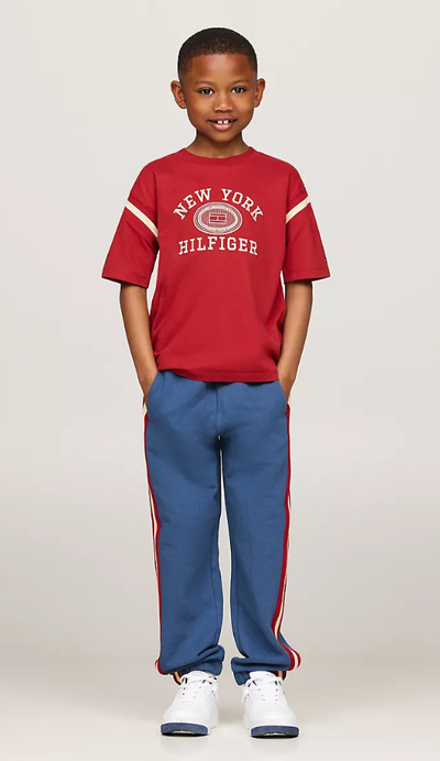 A boy wearing Tommy Hilfiger Kids embroidered varsity logo t-shirt