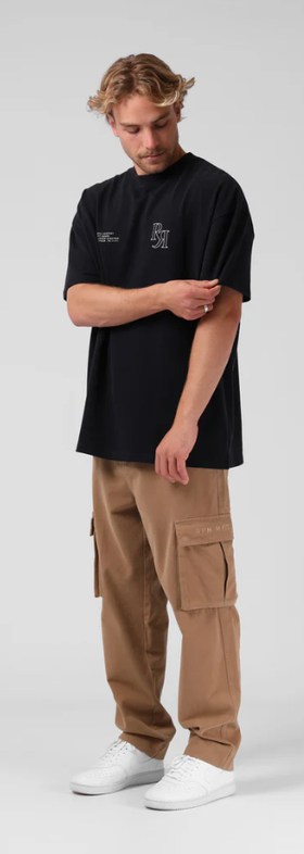 A man wearing a RPM street sanded os tee - vintage black