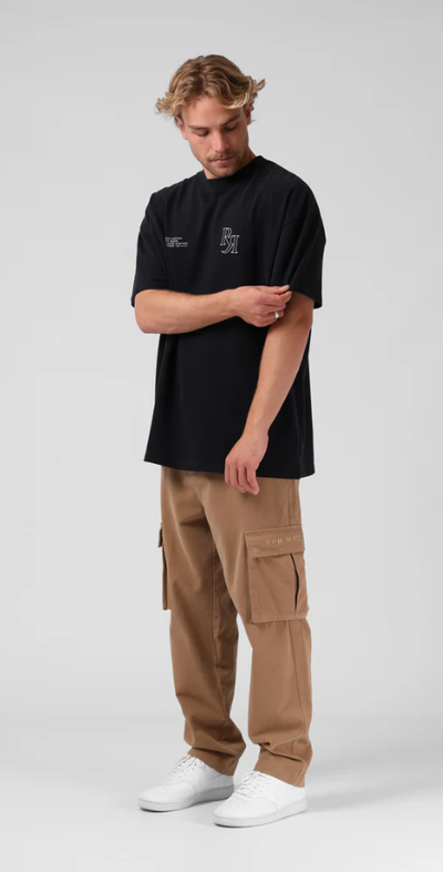 A man wearing a RPM street sanded os tee - vintage black
