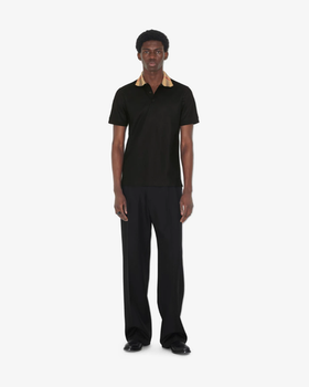 A man wearing Burberry Kids black cotton polo shirt