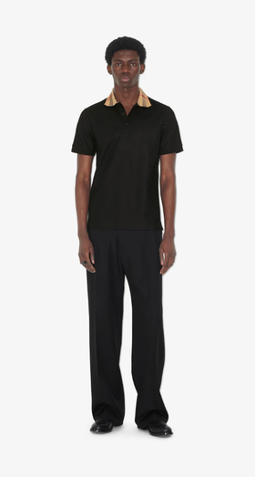 A man wearing Burberry Kids black cotton polo shirt