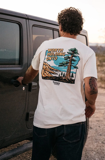A man wearing Tanner Goods white adventure t-shirt