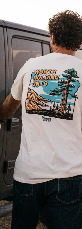 A man wearing Tanner Goods white adventure t-shirt