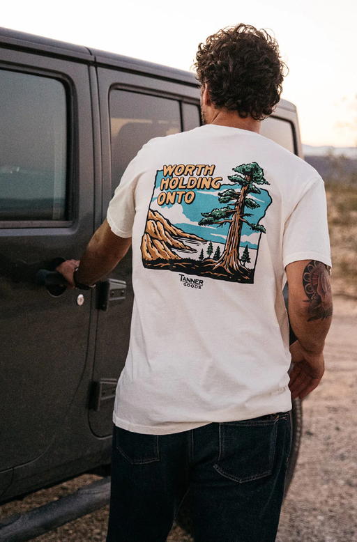 A man wearing Tanner Goods white adventure t-shirt
