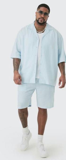 A man wearing a Boohoo Plus oversized light blue button up with matching shorts
