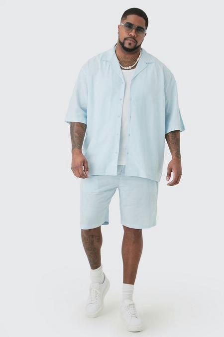 A man wearing a Boohoo Plus oversized light blue button up with matching shorts