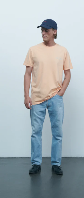A man wearing Maison Labiche melon color mini manufacture popincourt t-shirt