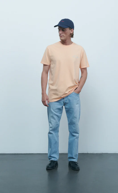 A man wearing Maison Labiche melon color mini manufacture popincourt t-shirt
