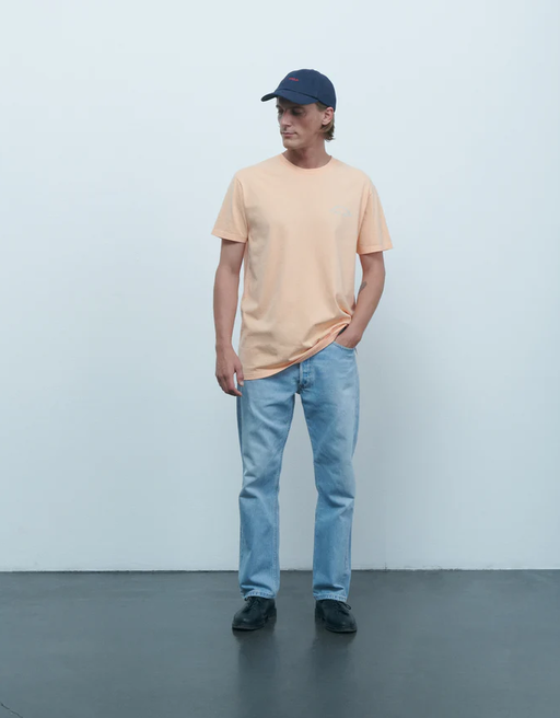 A man wearing Maison Labiche melon color mini manufacture popincourt t-shirt