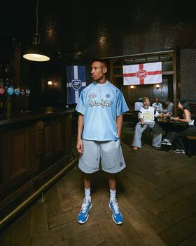 A man wearing broken planet light blue football jersey
