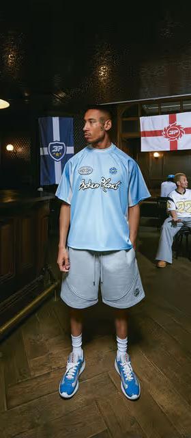A man wearing broken planet light blue football jersey
