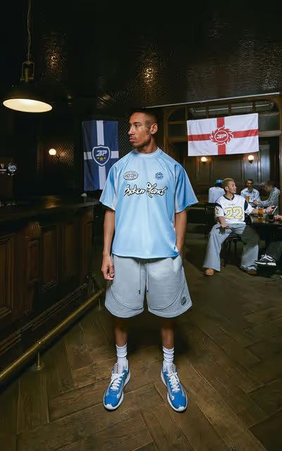 A man wearing broken planet light blue football jersey