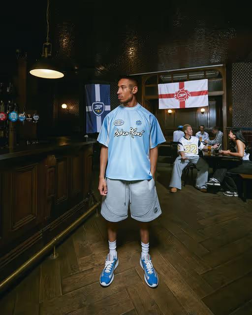 A man wearing broken planet light blue football jersey