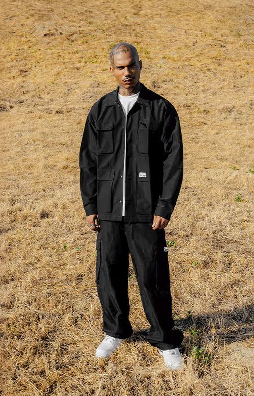A man wearing pro club men's heavyweight safari jacket - black