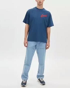 A man wearing Coach dark denim boardwalk specials t shirt in organic cotton