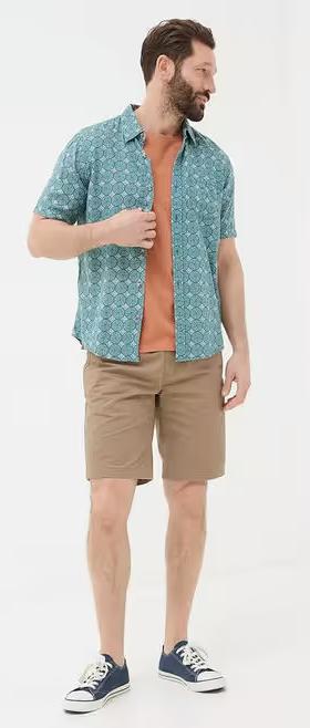 A man wearing Fatface teal green short sleeve snave tile print shirt