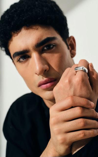 A man wearing Tom Wood crest ring