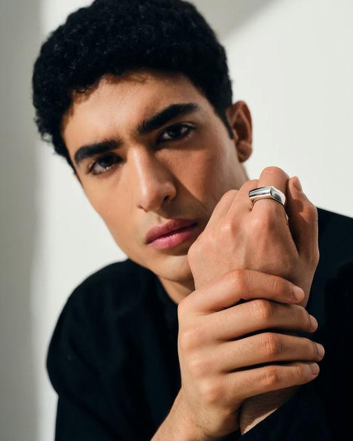 A man wearing Tom Wood crest ring