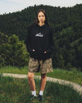A woman wearing Jiberish Boston Store script french terry hoodie black
