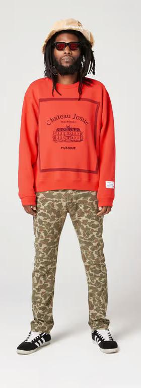 A man wearing Gallery Dept red musique crewneck sweatshirt