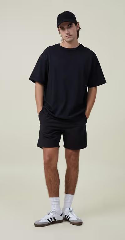A man wearing Cotton On black easy short