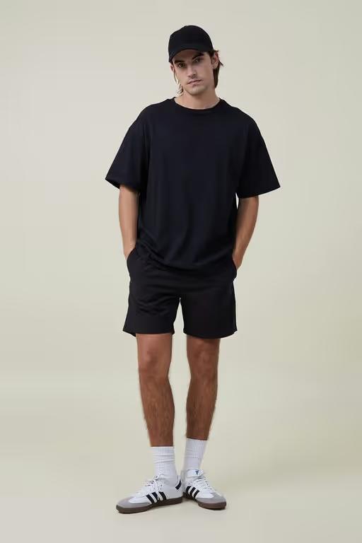 A man wearing Cotton On black easy short