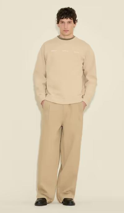 A man wearing Holzweiler duke national crew sand
