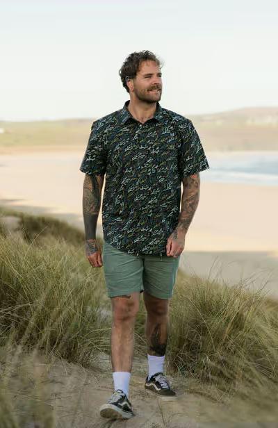 A man wearing passenger ocean current black way ripstop short sleeve shirt